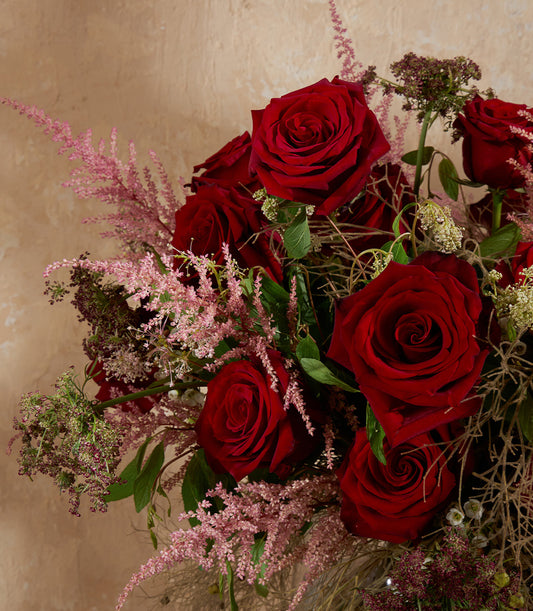 Deep red rose vase with pink filler flowers and eucalyptus greenery, lush romantic arrangement