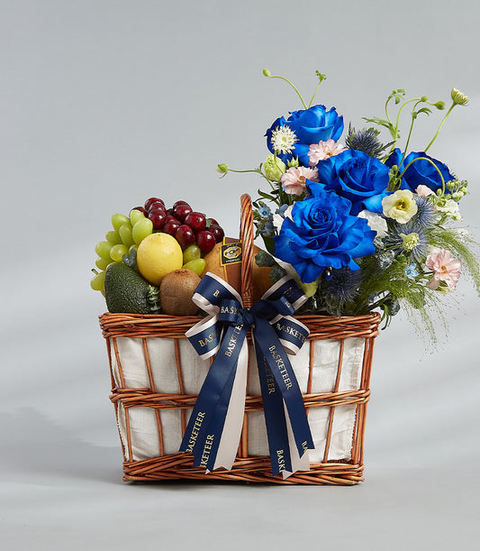Premium blue roses and fresh fruit gift basket with Ecuador roses, grapes, cherries, and seasonal produce