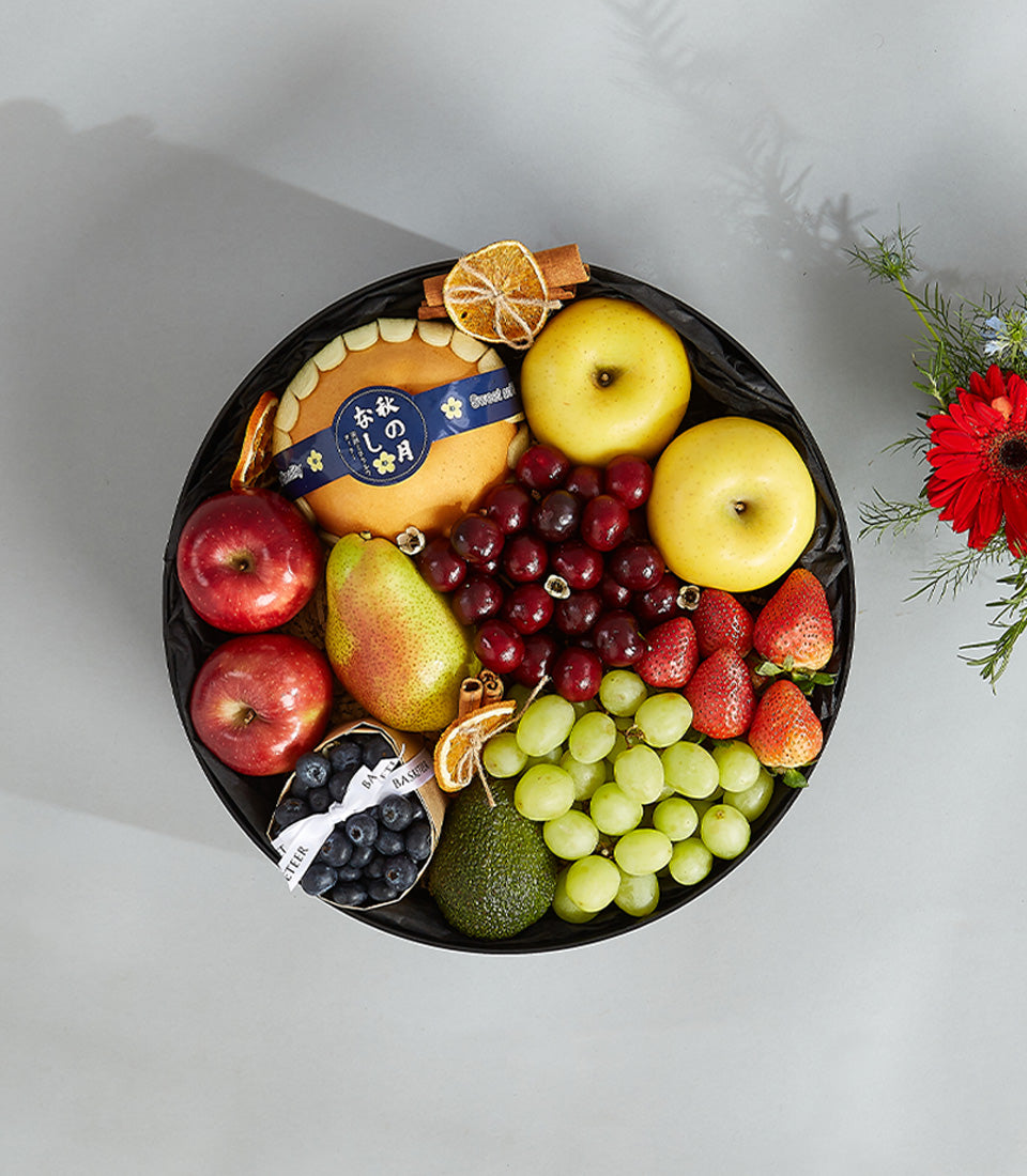 Premium harvest fruit basket with blueberries, avocado, apples, cherries, and fresh seasonal fruits on black platter
