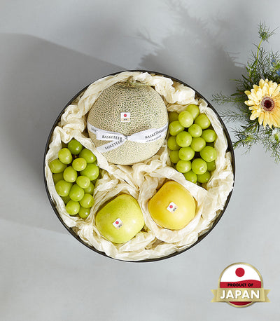 Luxury Japanese fruit gift basket with netted melon, grapes, apples in black round box with white ribbon