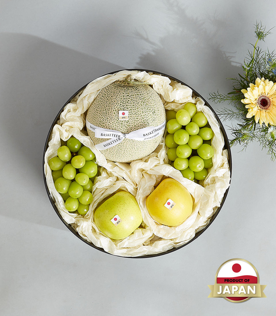 Luxury Japanese fruit gift basket with netted melon, grapes, apples in black round box with white ribbon