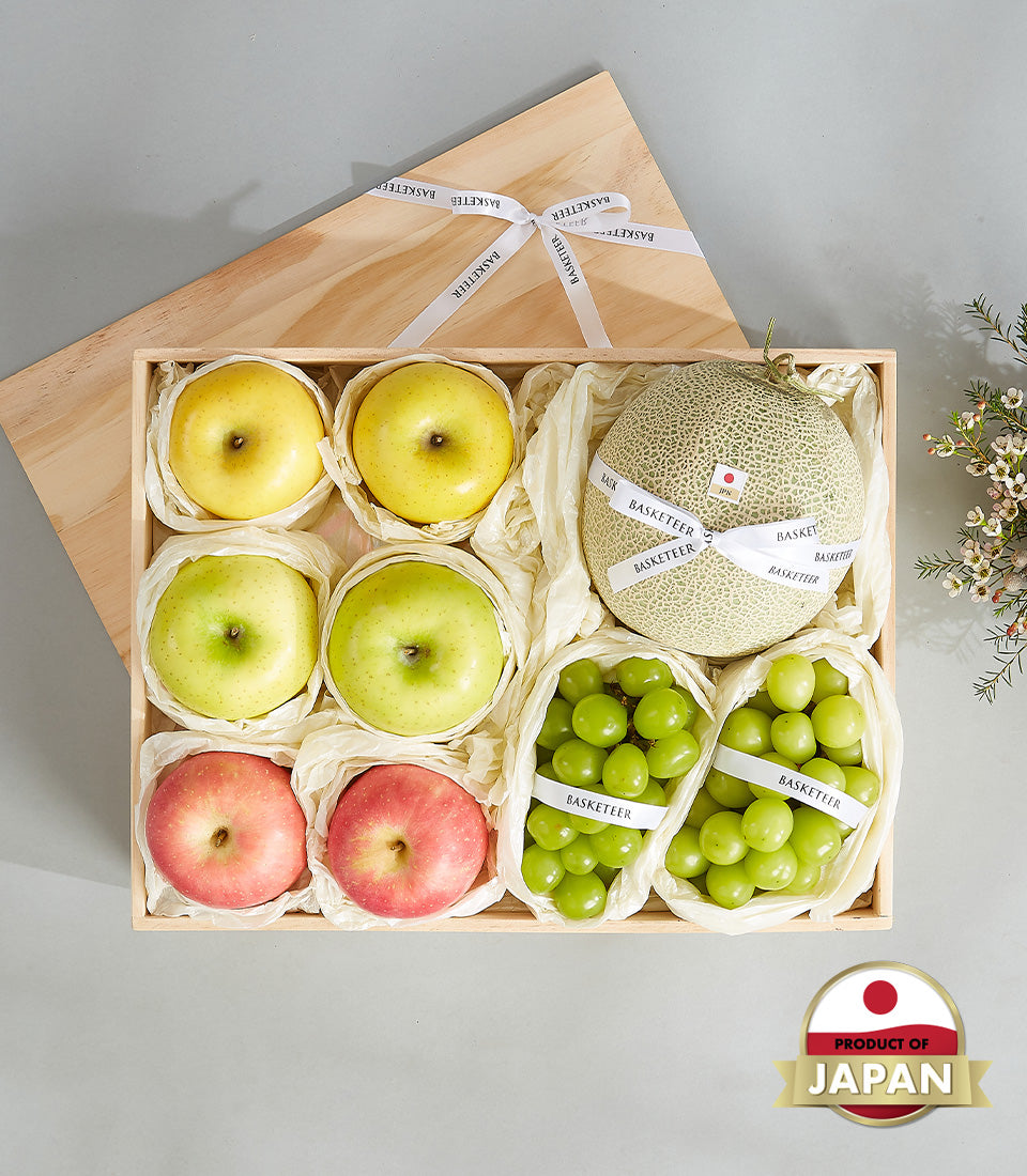 Premium Japanese fruit gift box with apples, cantaloupe melon, and grapes in wooden presentation case