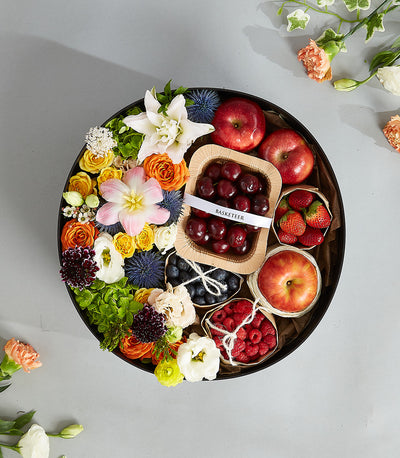 Premium mixed berry and floral gift basket with fresh flowers, cherries, strawberries, blueberries and apples in black
