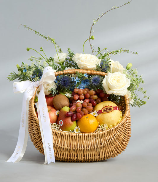 Elegant white rose and fresh fruit wicker basket with Ecuador roses, apples, grapes, and pears