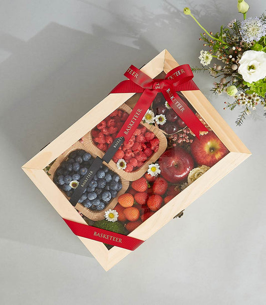Deluxe wooden fruit crate with fresh berries, strawberries, apples and cherries, red ribbon bow, birthday gift hamper