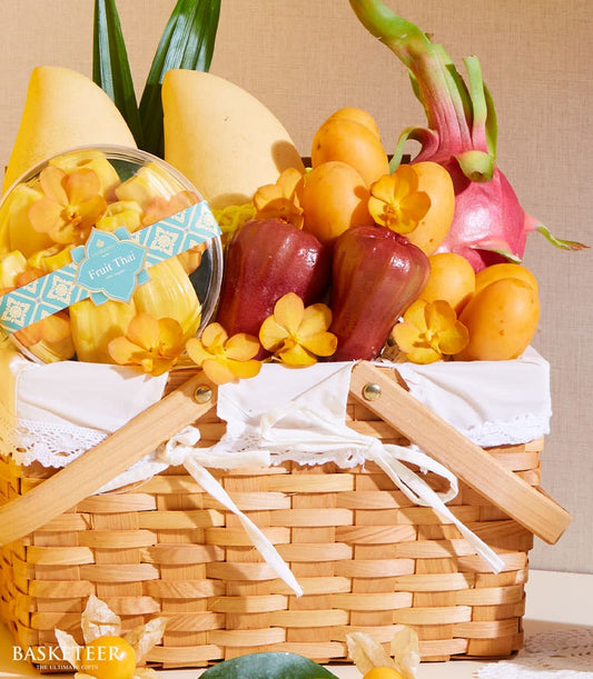 Vibrant wicker fruit basket with Thai mangoes, dragon fruit, rose apples, and fresh orchids