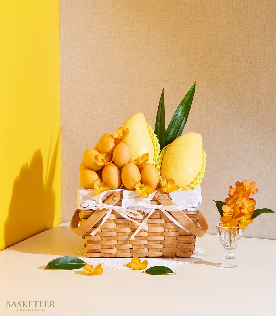 Premium Thai mango and Marian plum gift basket with white lace trim and fresh orchids