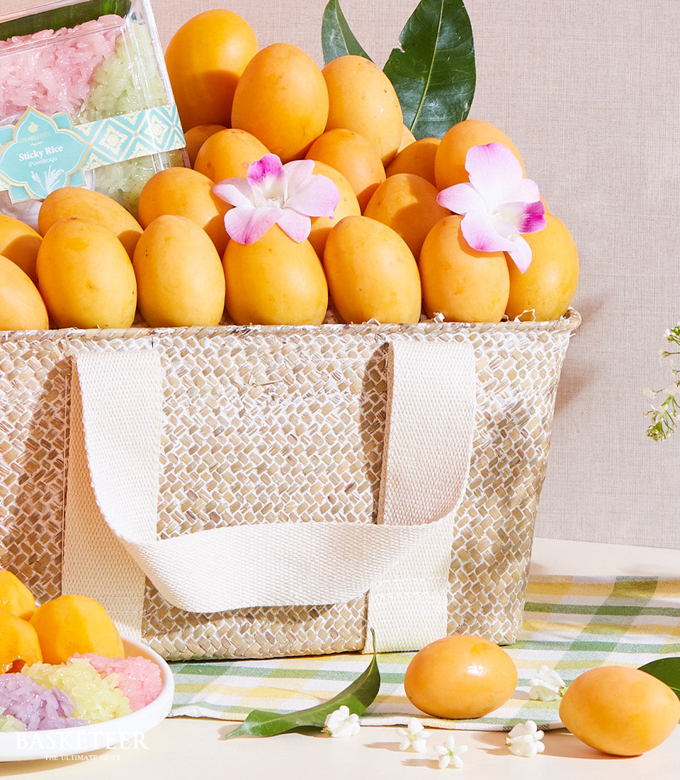 Premium yellow mangoes with sticky rice and orchids in woven basket, Thai tropical fruit gift