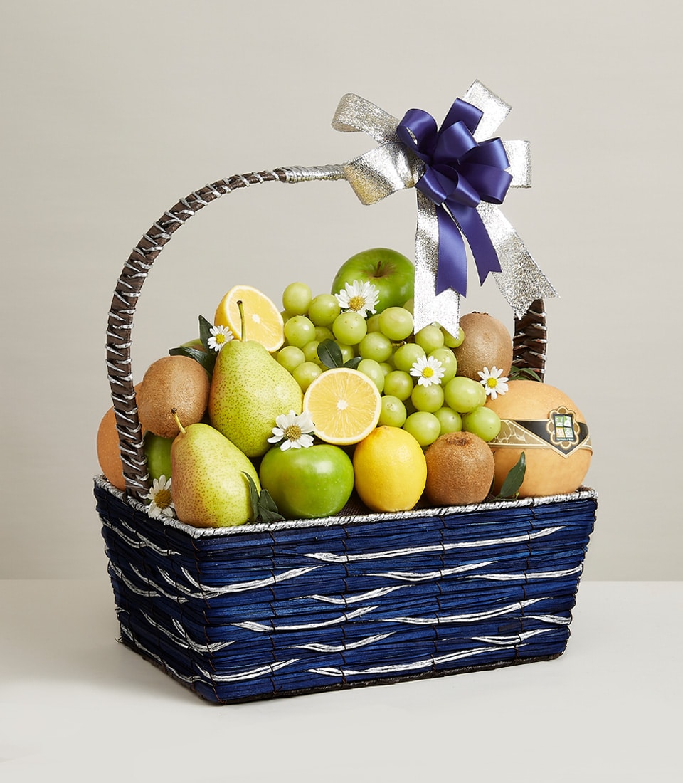 Dark blue woven fruit basket with fresh grapes, apples, pears, and kiwis, silver ribbon bow, artisan gift hamper