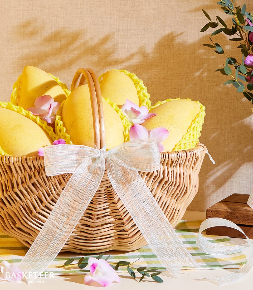 Golden mango gift basket with white ribbon bow and orchid accents