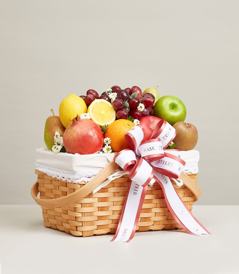 Gala luxury fruit basket with woven wood weave, fresh assorted fruits, white lace liner, and rose gold ribbon bow