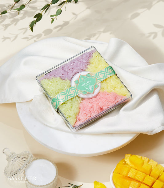 Colorful sticky rice gift box with purple, green, yellow, and pink compartments, tied with teal ribbon