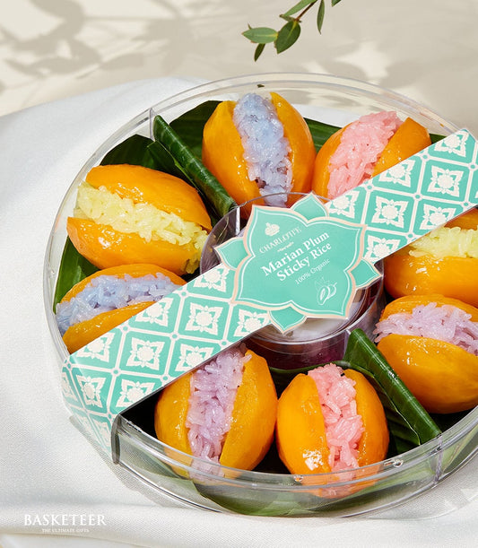 Marian plum halves filled with pastel sticky rice in clear gift container, artisan Thai tropical fruit dessert