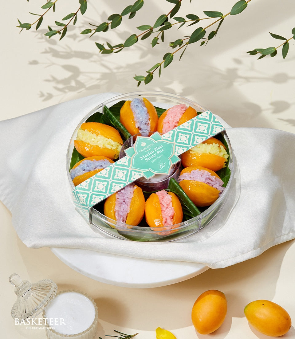 Colorful Marian plum halves filled with vibrant sticky rice in yellow, blue, pink, and purple in clear gift container
