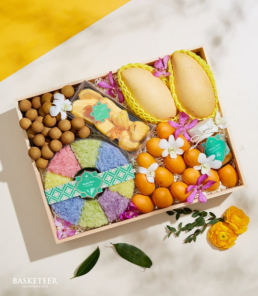Wooden gift box with Thai mangoes, longans, dried jackfruit, sticky rice, marian plums, and white orchids