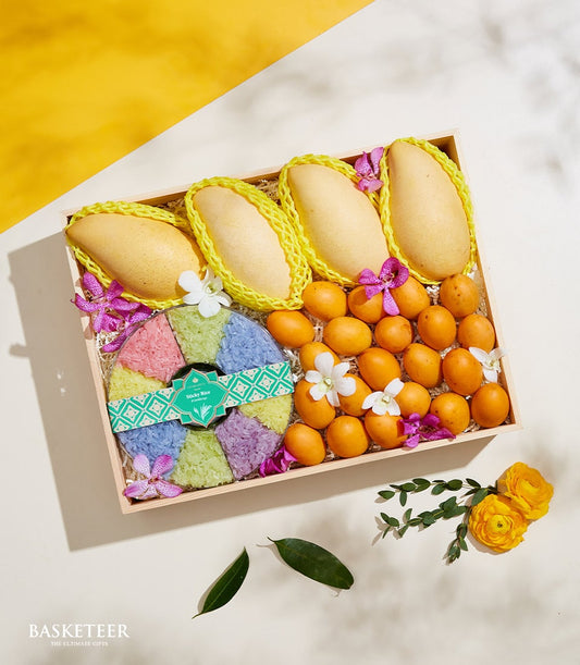 Wooden gift box with four yellow mangoes and Marian plums, colorful sticky rice, and orchids