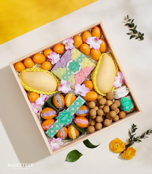 Thai summer fruits gift box with mangoes, longan, and Marian plums, artisan sticky rice, and fresh orchids