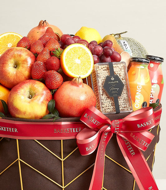 Basketeer premium hamper delivery in Bangkok: apples, pomegranates, honey and juice in a geometric basket tied with a branded red ribbon. A luxurious gift.