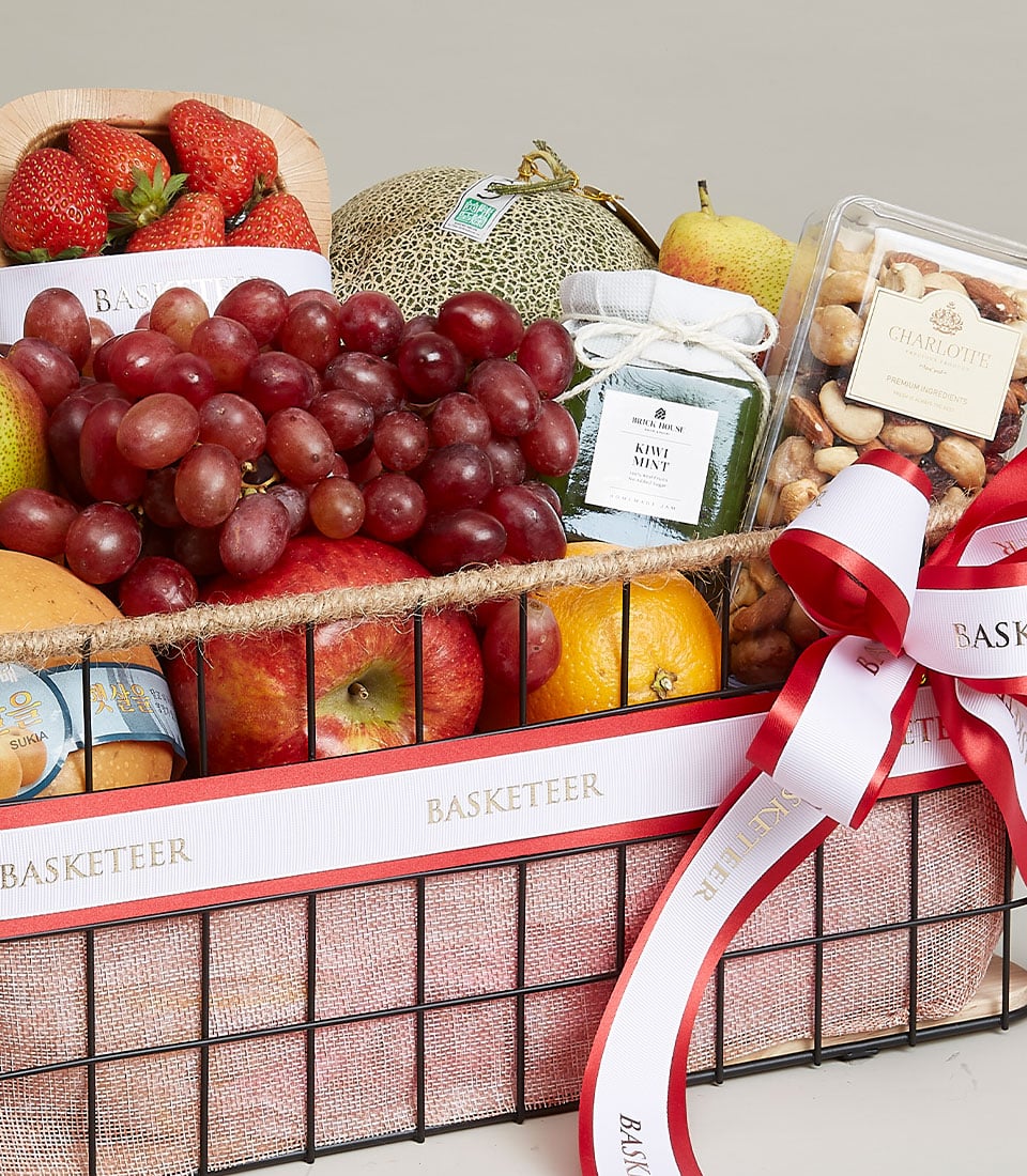 Luxury fruit and wellness gift basket with fresh grapes, apples, oranges, artisan jam, and gourmet nuts