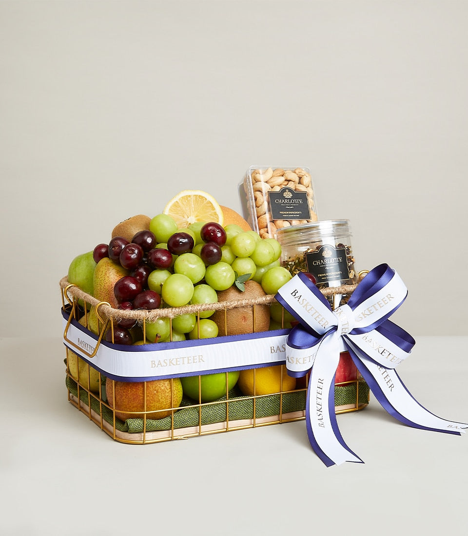 Opulent fresh fruit basket with grapes, pears, apples, cherries, kiwis, cashews and specialty tea in gold wire frame