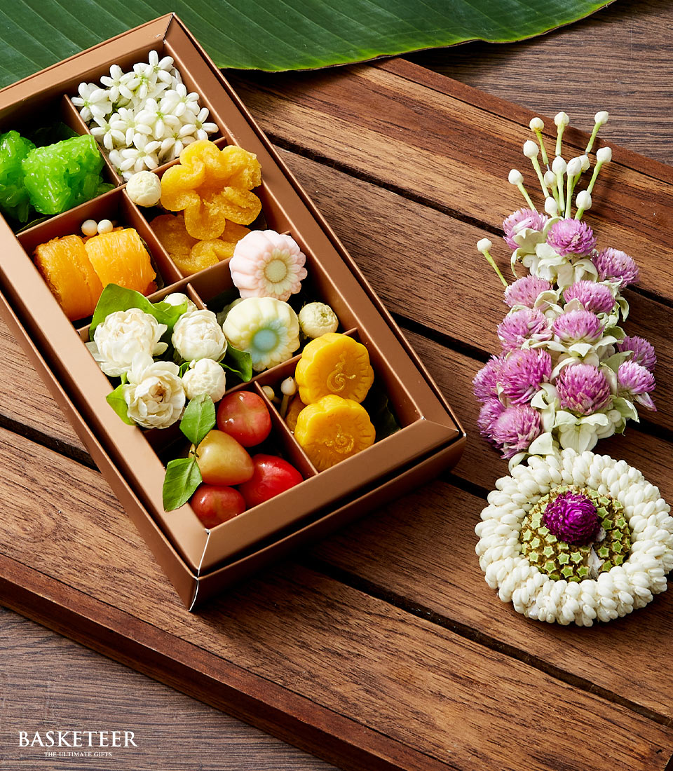 Premium Thai Songkran gift set with jasmine flowers, sticky rice, and traditional desserts in compartmentalized box