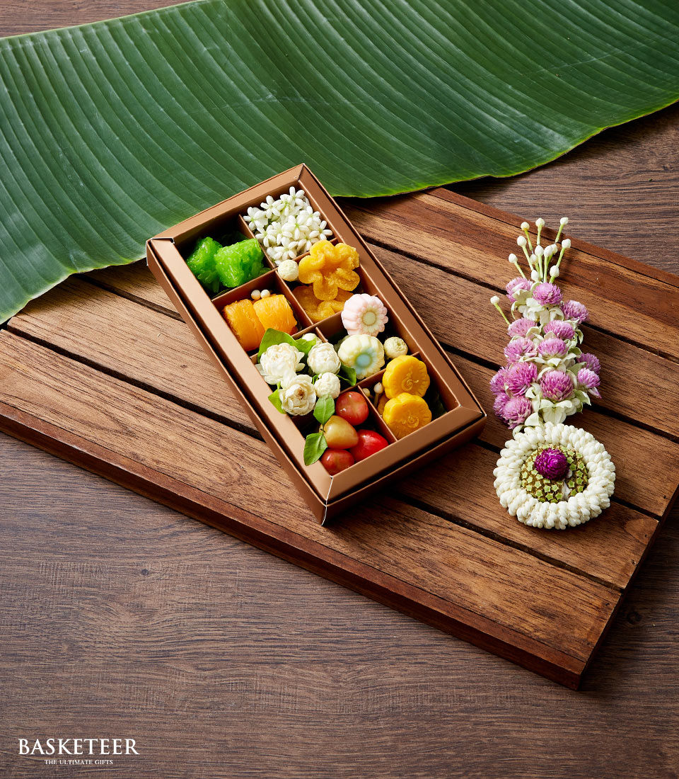 Metallic bronze gift box with assorted Thai sweets and jasmine flowers for Songkran celebration