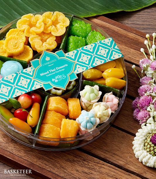 Teal-banded round container of colorful traditional Thai desserts and flower-shaped sweets for Songkran celebration