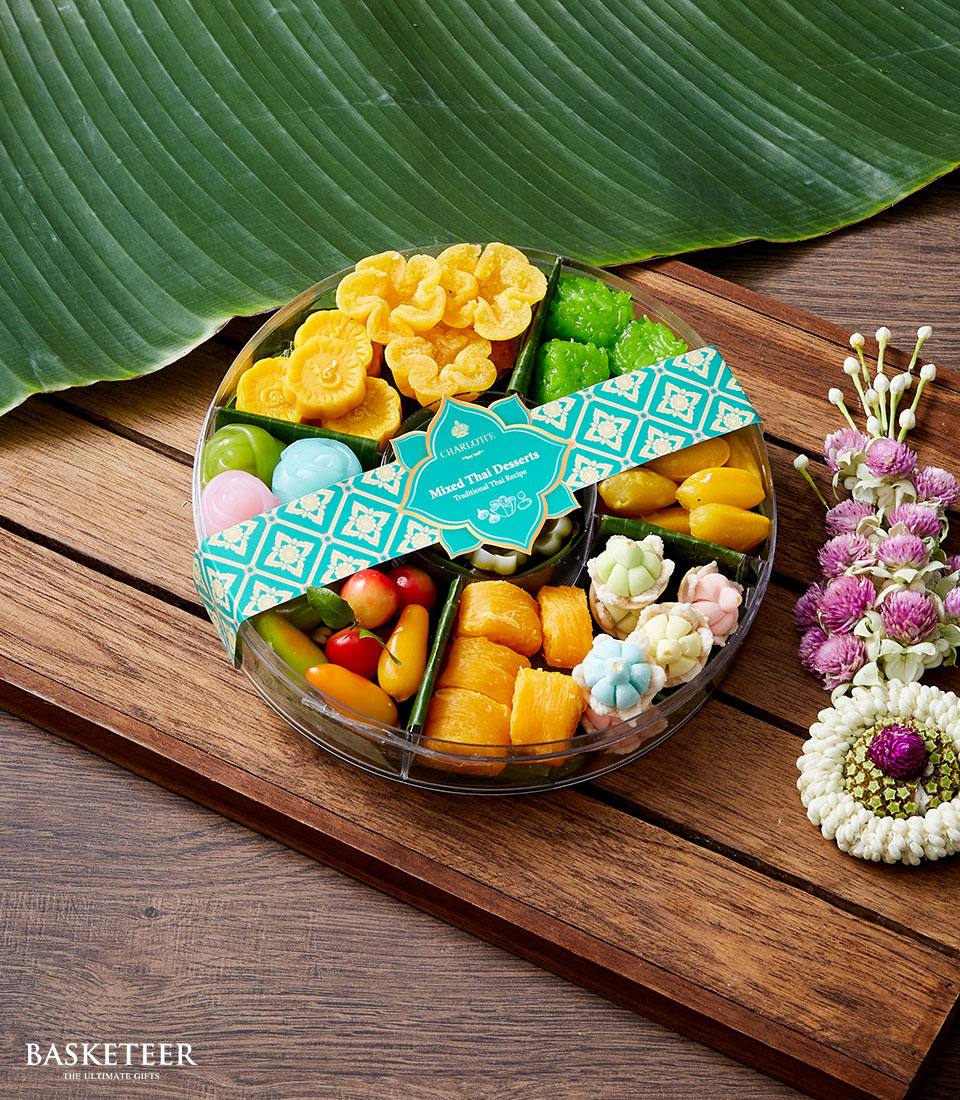 Colorful Thai dessert gift basket with teal ribbon, traditional sweets in clear container for Songkran celebration