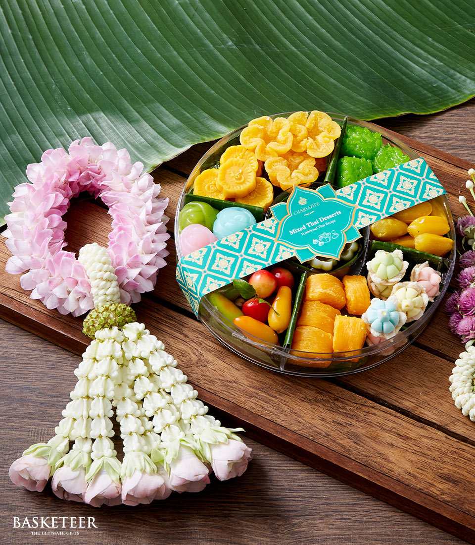 Circular gift set with colorful traditional Thai desserts and jasmine floral garland for Songkran celebration