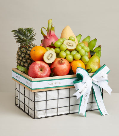 Luxury fruit basket with pineapple, mango, dragon fruit, and seasonal produce in woven wooden frame