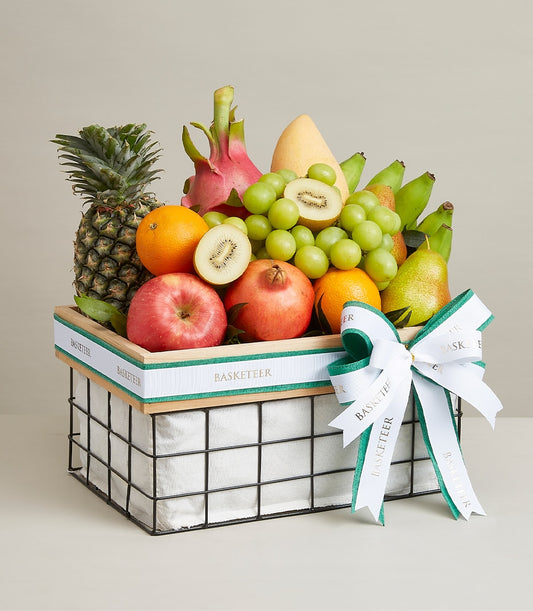 Luxury fruit basket with pineapple, mango, dragon fruit, and seasonal produce in woven wooden frame