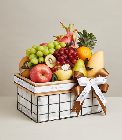 Luxury fruit gift basket with fresh tropical and orchard fruits, black metal frame with wooden trim and white ribbon bow