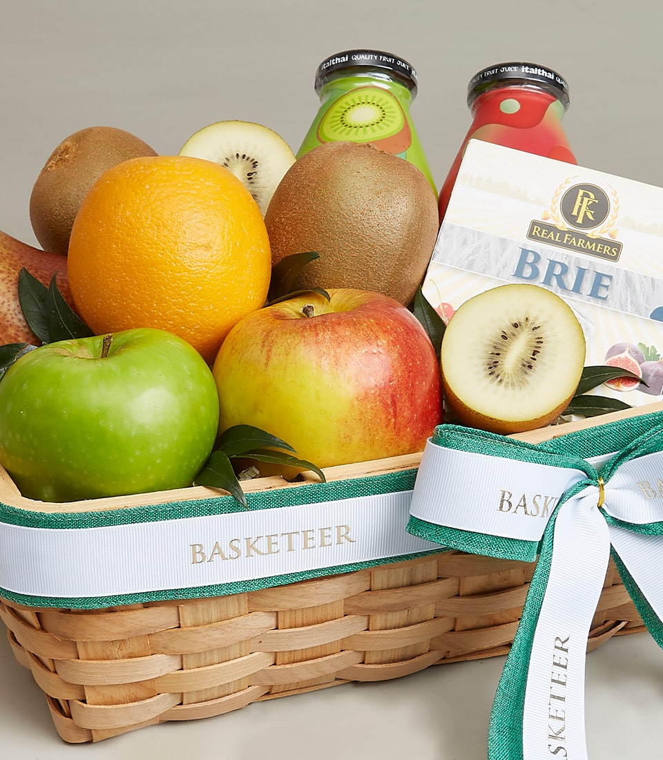 Woven basket gift box with fresh kiwis, apples, orange, artisan Brie cheese, and fruit juices