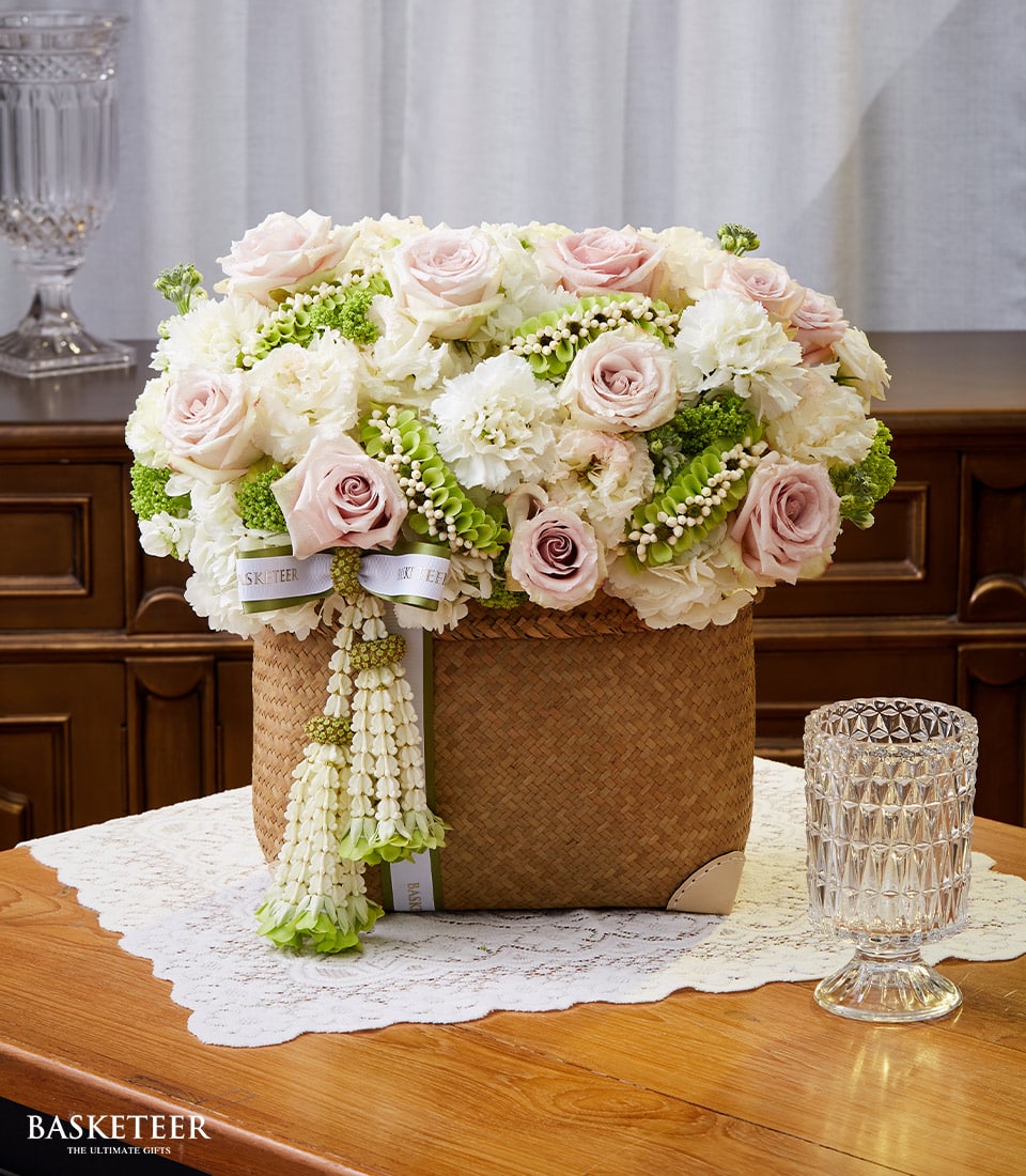 Light pink roses and white carnations in woven rattan basket, Thai New Year Songkran gift arrangement