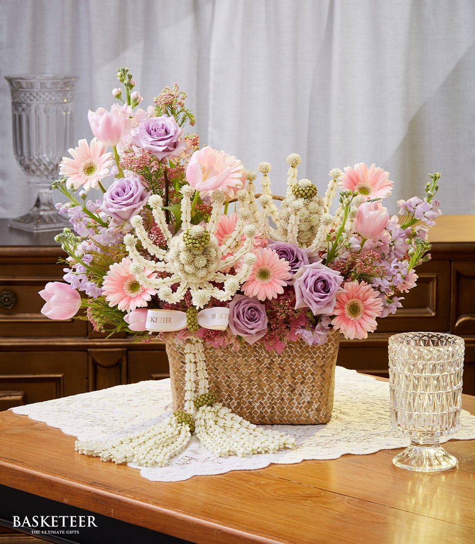 Pink tulips and roses with white jasmine garlands in woven basket for Thai New Year celebrations