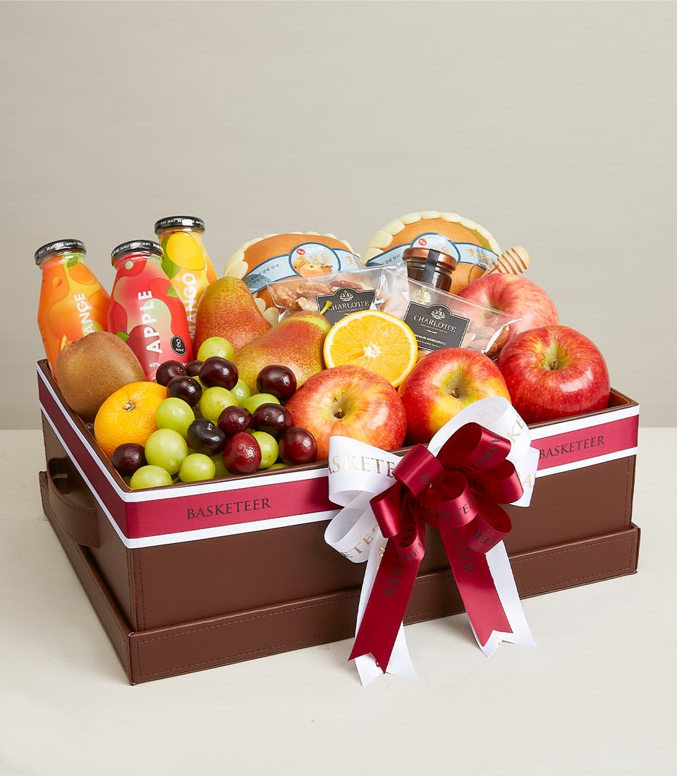 Luxury wellness gift basket with fresh fruits, organic juices, gourmet treats, and honey in brown leather box