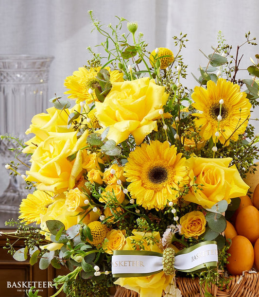 Vibrant yellow roses and gerberas with fresh mangoes in woven basket, Songkran gift hamper