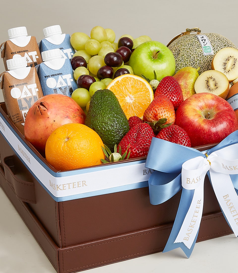 Premium fresh fruit and wellness gift basket with apples, berries, citrus, and plant-based milk in luxury brown leather