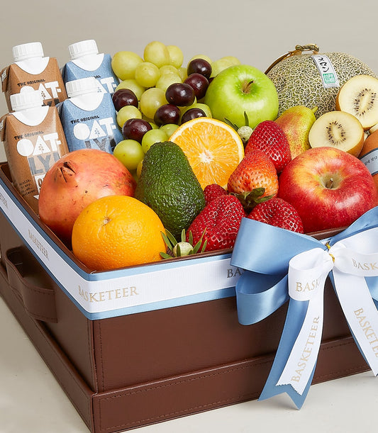 Premium fresh fruit and wellness gift basket with apples, berries, citrus, and plant-based milk in luxury brown leather