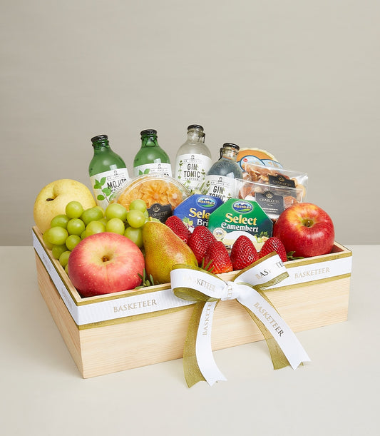 Luxurious wooden gift box with fresh fruits, artisan cheeses, premium beverages and gourmet treats