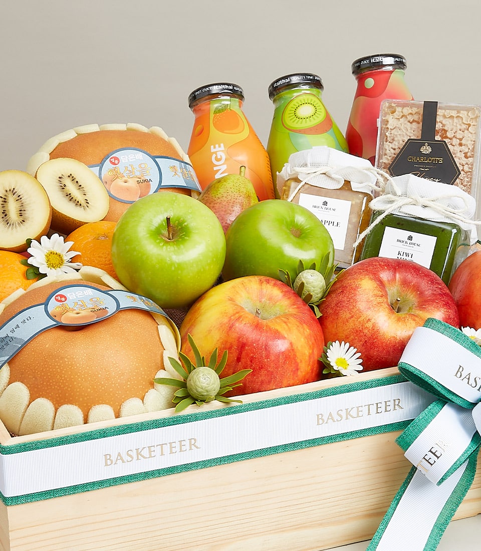 Premium fruit gift crate with fresh apples, pears, artisan preserves, and juices in natural wooden basket