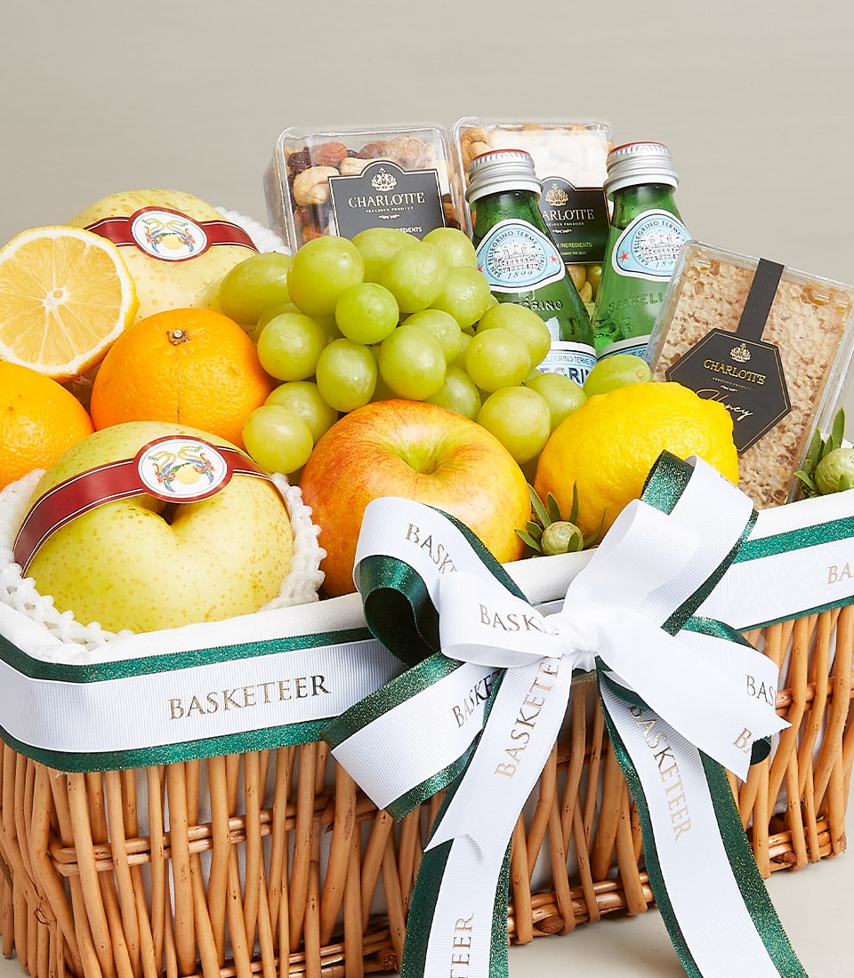 Wicker gift basket with fresh grapes, oranges, lemons, pears, apples, gourmet nuts, sparkling water, and honeycomb