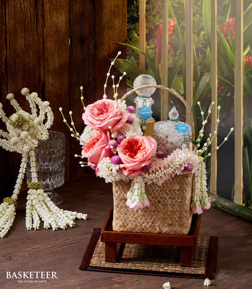 Luxury floral gift basket with pink roses, jasmine garland, and artisan scented waters for Songkran celebrations