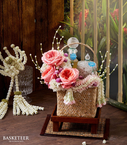 Luxury floral gift basket with pink roses, jasmine garland, and artisan scented waters for Songkran celebrations