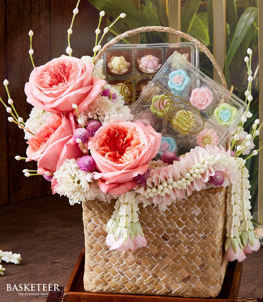 Pink rose bouquet with Thai flower-shaped desserts in woven basket, Songkran celebration gift