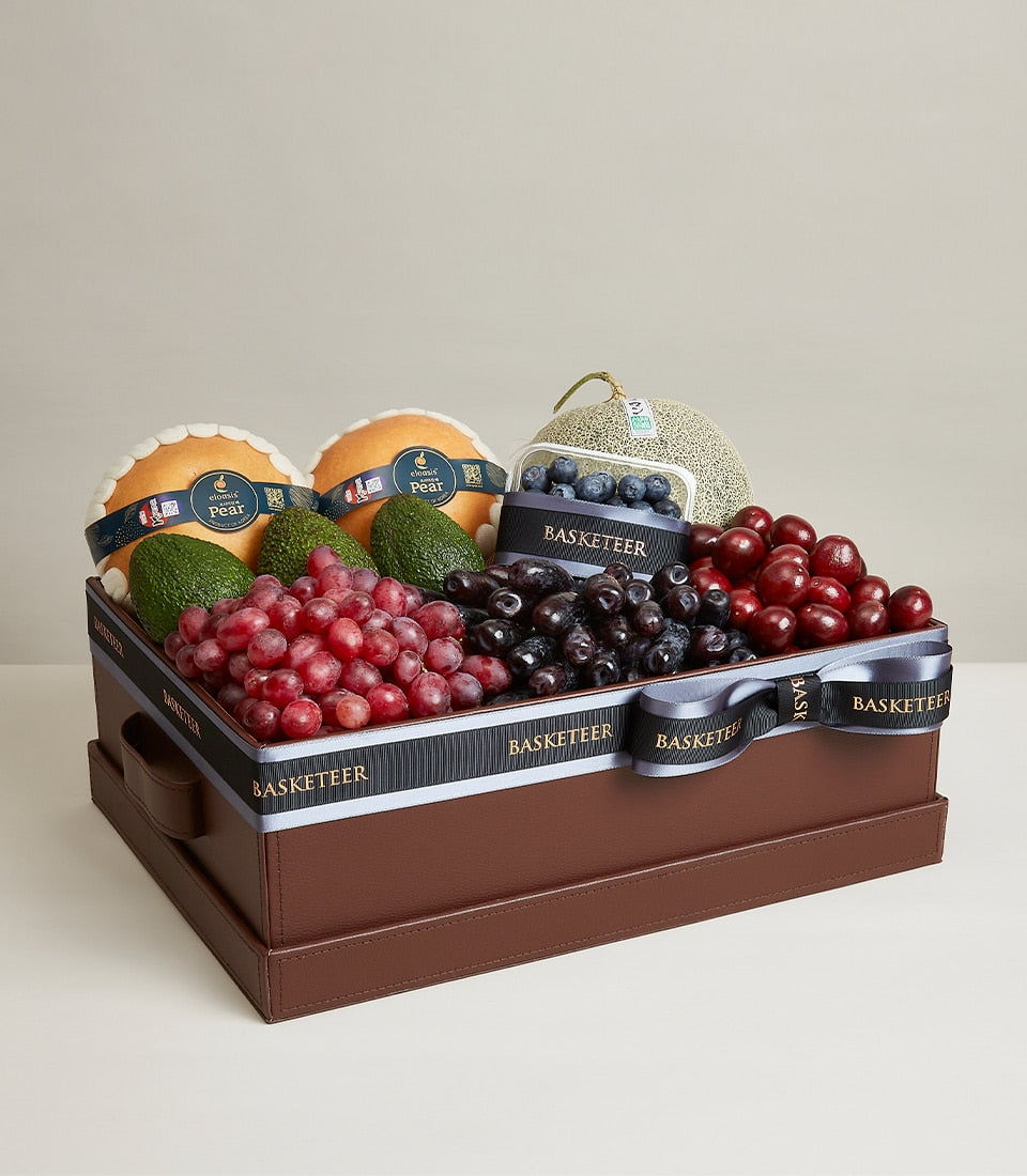 Luxury fruit selection box with pears, avocados, grapes, cherries, blueberries and melon in faux leather presentation case
