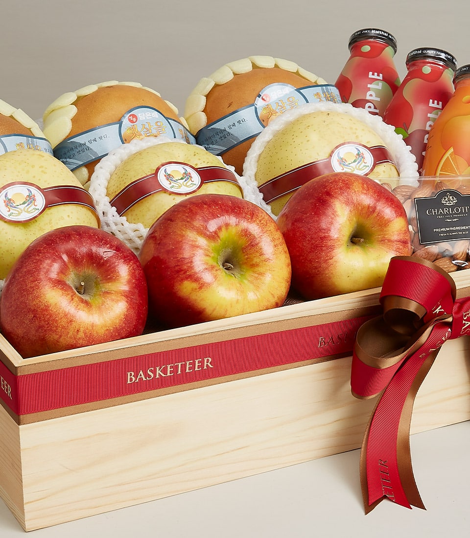 Luxury wooden gift box with fresh apples, pears, premium juices, and almonds with red ribbon