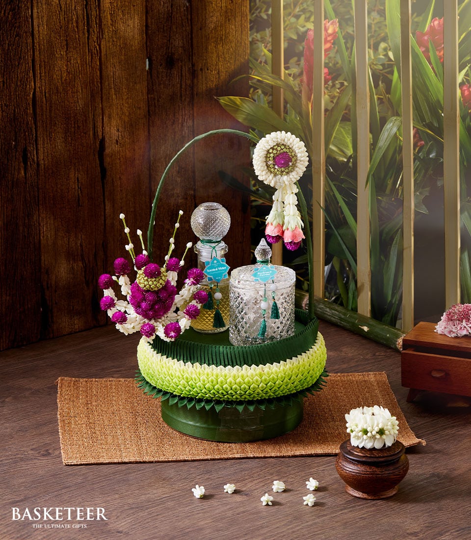 Thai Songkran perfume gift set with scented water, glass bottles, fresh flowers and traditional phuang malai garland on
