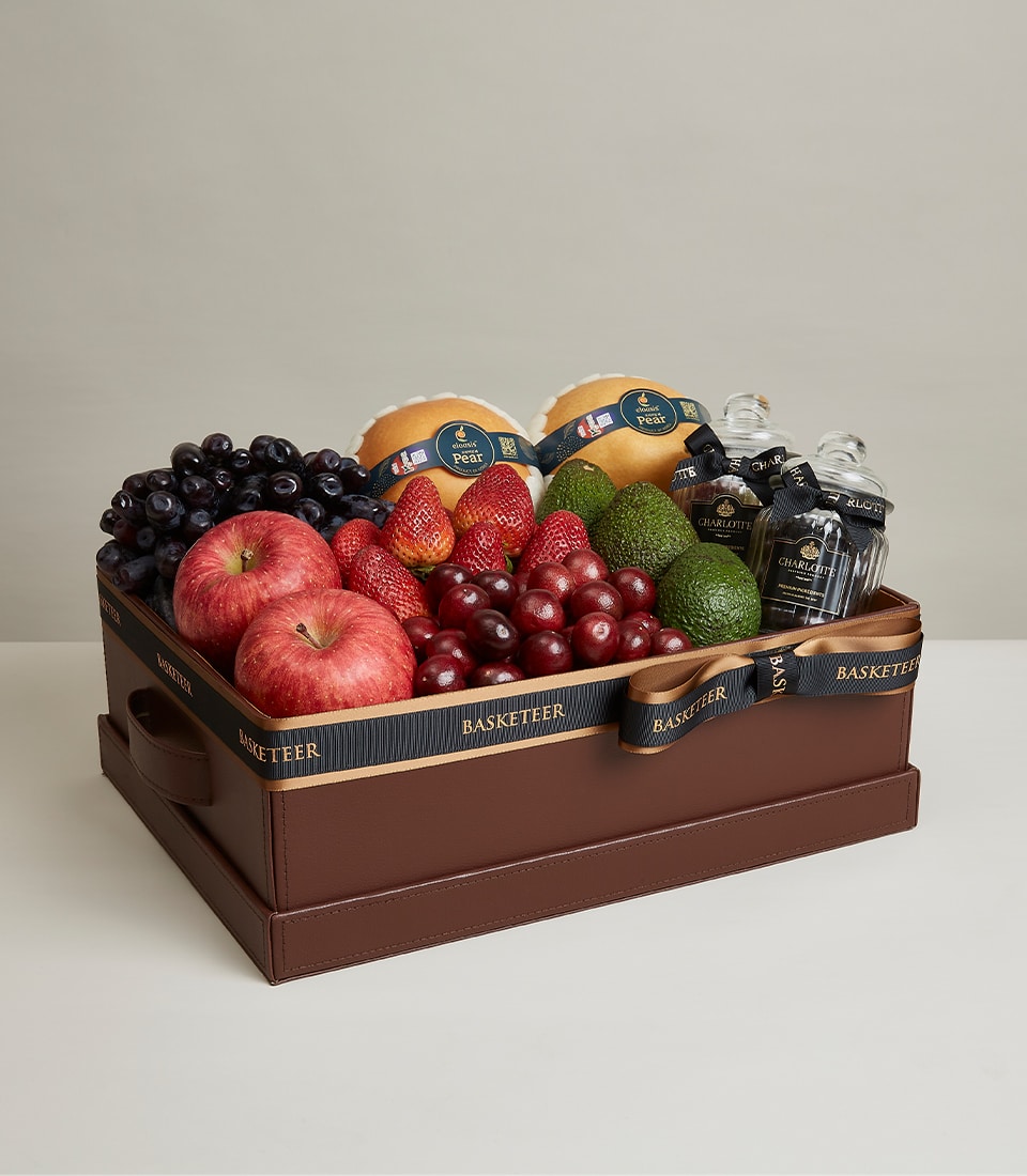 Luxurious leather gift box with fresh grapes, strawberries, apples, avocados, pears and gourmet preserves