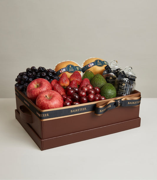 Luxurious leather gift box with fresh grapes, strawberries, apples, avocados, pears and gourmet preserves